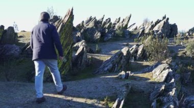 Madrid, Sierra del Rincon 'da keskin kayalarla dolu garip bir arazide dinlenen yürüyüşçü.