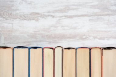 Farklı renklerde, ahşap bir arka planı olan bir kitap. Kopyalama alanı olan fotoğraf