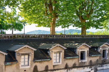 Fransa 'nın Pau kentindeki Pireneler' e bakan eski binalar ve kamu parkı