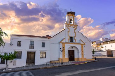 İspanya 'da bir köyde gün batımında kulesinde leylekler olan küçük bir kilise, Agudo, Ciudad Real.