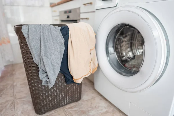stock image Clothes hanging from a basket ready to put them in the automatic washing machine