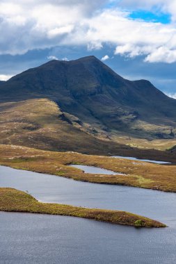 İskoçya 'da tipik bir İskoçya manzarasında gölleri ve otlak otlakları olan yüksek yeşil dağlar.