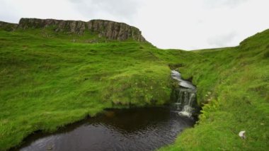 İskoçya 'nın İskoçya' daki Skye Adası 'nı kaplayan yeşil çayırlardaki küçük şelale.