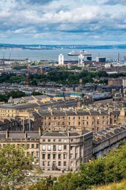 Edinburgh şehrinin panoramik manzarası, arka planda deniz ve iskan binaları, İskoçya