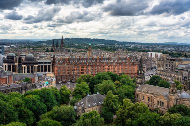 Edinburgh şehrinin panoramik manzarası arka planda dağlarla birlikte kalenin tepesinden İskoçya.