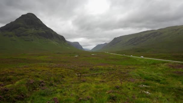 スコットランドのハイランドのグレンコーの緑の谷を横断する車がいっぱいの道路 — ストック動画
