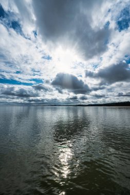Güneş doğarken deniz suyuna çarpıcı bir gökyüzü yansıyan deniz manzarası, Edinburgh.