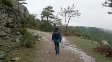 Sırt çantalı bir adam, Madrid, Guadarrama ormanında bir patika boyunca yürüyor.