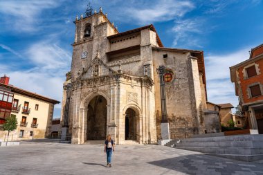 İspanya 'nın Bask Bölgesi, Salvatierra köyündeki büyük taş kiliseye bakan turist kadın