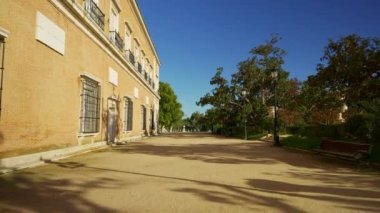 Madrid, Aranjuez 'in büyük kraliyet bahçelerine giriş bankları ve dalları arasında güneş olan büyük ağaçlarla.
