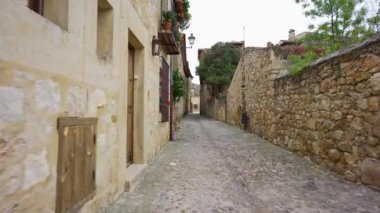 Segovia, Pedraza 'nın ortaçağ kasabasının pencerelerinde taş duvarlar ve çiçekler olan dar sokaklar