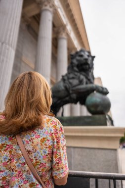 Madrid, İspanya 'daki Milletvekilleri Kongresi' nde aslan heykeli önünde sırtını dönmüş bir kadın..