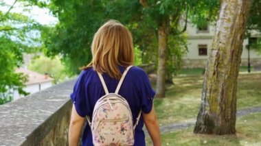 Turist kadın, Bask Bölgesi 'nin Salvatierra köyündeki kilisenin bahçelerinde geziniyor.