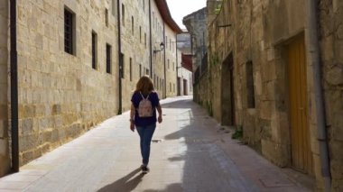 Kuzey İspanya 'daki Salvatierra Bask köyünün sokaklarında gezinen kadın turist.