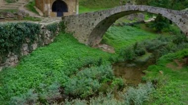 Ortaçağ kilisesinin yanında gezinen turist kadın kaya uçurumunun yanında, Tobera, Burgos