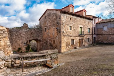 Siguenza yakınlarındaki ortaçağ Palazuelos köyünde eski taş evler ve ahşap banklar.