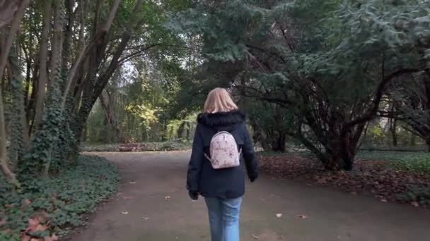 彼女と一緒にスペインのヴァラドリッドにある大規模な公共公園の通りに戻った女性 — ストック動画