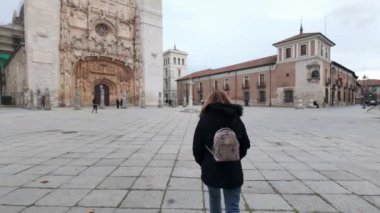 İspanya 'nın Valladolid şehrinde San Pablo manastırının önünde yürüyen bir kadın..