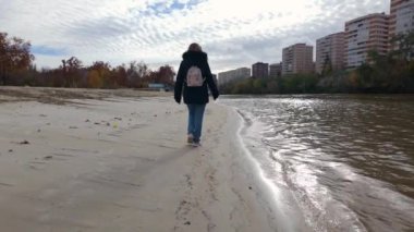 İspanya 'nın Valladolid kentindeki Pisuerga Nehri kıyısında sessizce gezinen turist kadın.