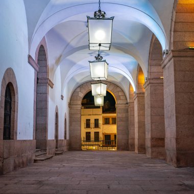 İspanya 'nın ortaçağ şehri Caceres' te taş kemerler ve büyük fenerlerle dolu bir geçit.