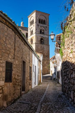 Trujillo, İspanya 'da bir ortaçağ kilise kulesine giden dar bir sokak..