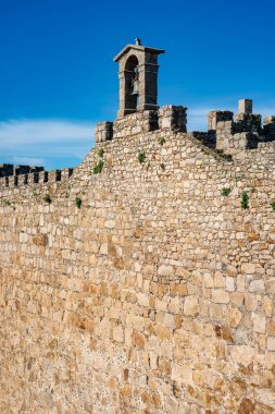 Binanın tepesinde çan kulesi olan büyük ortaçağ taş duvarı, Trujillo, İspanya
