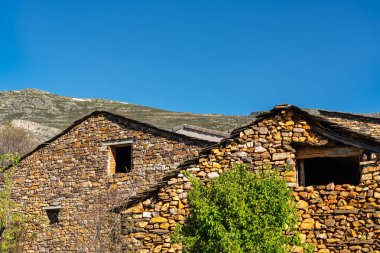 Guadalajara, Valverde 'nin kuzeyindeki dağlık bölgelerde siyah çatılı taş evler..