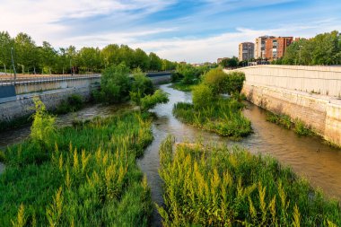 Manzanares river at sunset as it passes through the capital of Spain in Madrid. clipart