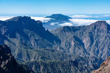 Bulutlardan yükselen volkanik bir volkanik kayanın etkileyici sıradağları, La Palma, Kanarya Adaları.