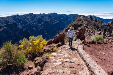 La Palma, Kanarya Adaları 'ndaki volkanik dağlarda yürüyüş yapan bir kadın.