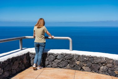 Kanarya Adaları 'ndaki La Palma volkanlarından deniz manzarasının tadını çıkaran turist kadın.