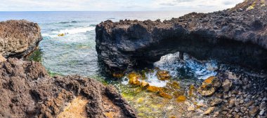 Volkanik kayaların kayalıkları dalgaların kırıldığı yerde taş kemerler oluşturur, La Faja, La Palma Adası