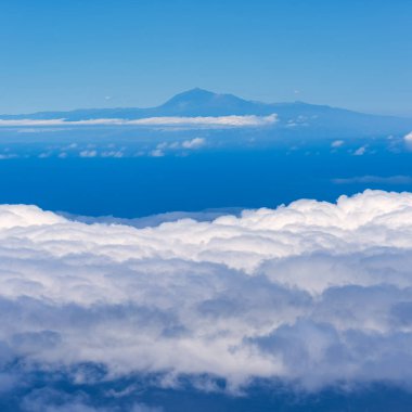 Teide yanardağının silueti ayaklarının dibinde bir bulut denizi, Kanarya Adaları 'ndaki bir uçağın hava manzarası.