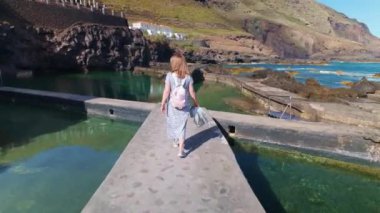 Doğal deniz suyu havuzlarının yanında yürüyen turist kadın, La Fajana, La Palma