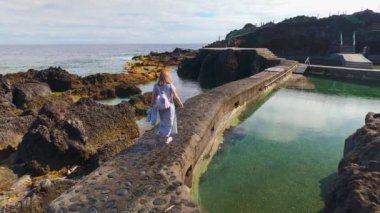 Doğal deniz suyu havuzlarının yanında yürüyen turist kadın, La Fajana, La Palma