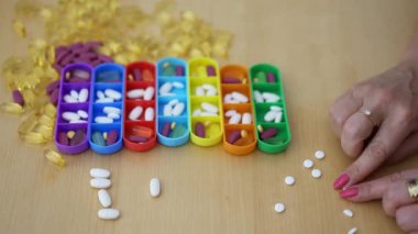 Kadınların elleri günlük ilaçlar için ilaç kutularına koymak için hapları ikiye bölüyor..