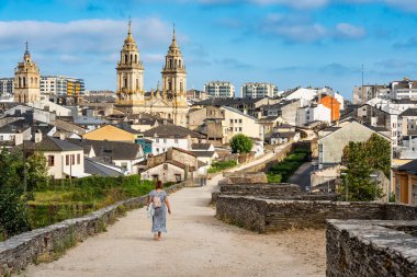 Roma duvarından, bir Dünya Mirası Alanından ve anıtın üzerinde yürüyen bir turistten oluşan İmparatorluk şehri Lugo 'nun şehri.