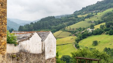 Asturias, Taramundi 'nin içinde yeşil çayırlar ve yeşilliklerle çevrili dağ evleri.