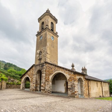 Asturias 'taki Taramundi dağ köyünde yüksek kulesi ve çan kulesi olan antik taş kilise.