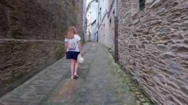 Mondonedo 'nun dar sokaklarında yürüyen turist kadın, Camino de Santiago, Galiçya' ya giden hacıların geçidi.