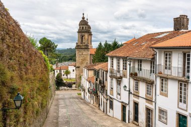 Galiçya 'nın Santiago de Compostela şehrinde eski binalar ve ortaçağ kilisesi bulunan Picturesque caddesi.