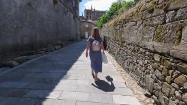 Galiçya 'nın ortaçağ şehri Tui' nin kaldırımlı sokaklarında gezen turist kadın.