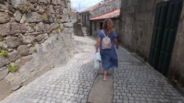 İspanya 'nın ortaçağ kasabası Tui' nin dar kaldırım taşı döşeli sokaklarında gezinen turist kadın.