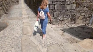 İspanya 'nın ortaçağ kasabası Tui' nin dar kaldırım taşı döşeli sokaklarında gezinen turist kadın.
