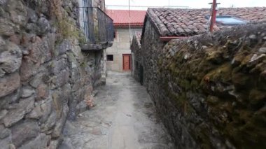 Galiçya 'nın Tui şehrinde kaldırımlı zemini ve eski taş evleri olan dar sokaklar..
