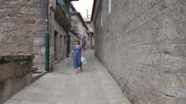 Galiçya 'nın ortaçağ şehri Tui' nin kaldırımlı sokaklarında gezen turist kadın.
