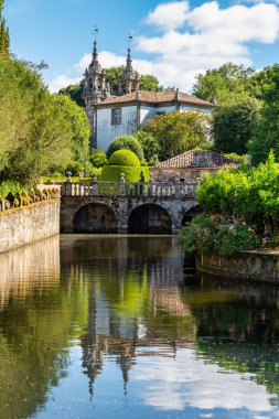 Galiçya 'nın Pazo de Oca bahçesinde kuğular ve çiçekli güzel bir göl