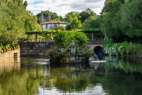 Galiçya 'nın Pazo de Oca bahçesinde kuğular ve çiçekli güzel bir göl