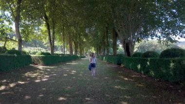 Galiçya, Pazo de Oca 'da ağaçlarla kaplı bir caddede rahatça yürüyen bir kadın.