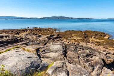 Galiçya 'nın La Toja adasında kaya oluşumlarıyla kıyı şeridi.
